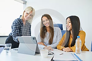 Smiling businesswomen using digital tablet in the office