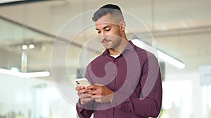 Smiling busy latin business man standing in office holding cellphone.