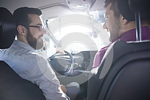 Smiling buyer and dealer during a test drive in a exclusive car