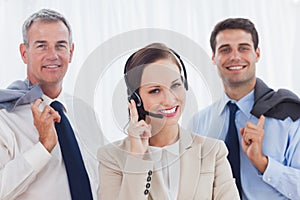 Smiling call center agent posing with her work team