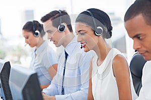 Smiling call center employees sitting in line