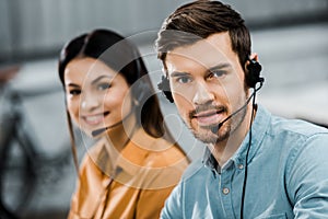 Smiling call center operators in headsets looking at camera