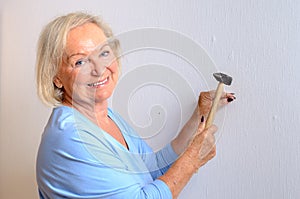 Smiling capable elderly woman doing DIY