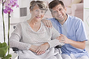 Smiling carer with senior in rest home