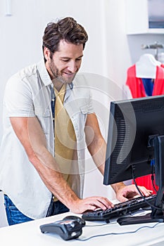 Smiling cashier typing