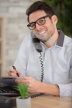 smiling casual businessman having phone call in office