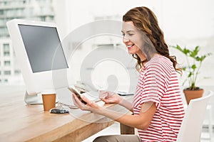 Smiling casual businesswoman using smartphone