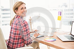 Smiling casual designer using computer and digitizer