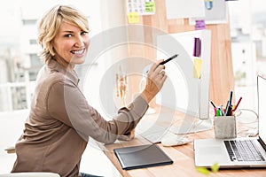 Smiling casual designer working at her desk