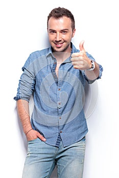 Smiling casual man shows thumb up