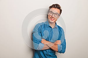 Smiling casual man wearing glasses standing with hands crossed