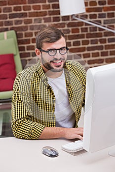 Smiling casual young man using computer