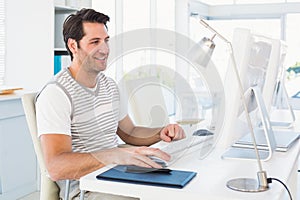 Smiling casual young man using computer