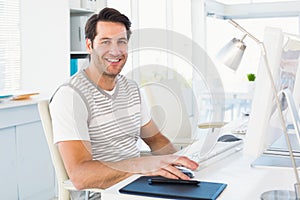 Smiling casual young man using computer