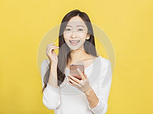 Smiling casual young woman holding smartphone