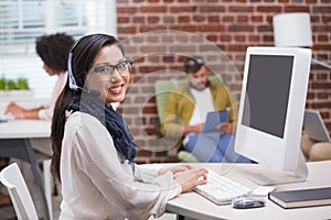 Smiling casual young woman using computer