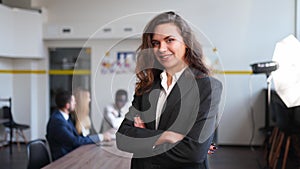 Smiling caucasian business woman in formal outfit looking at camera standing in office. Portrait of happy pretty