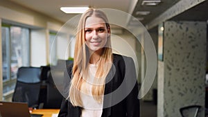 Smiling caucasian business woman in formal outfit looking at camera standing in office. Portrait of happy pretty