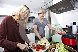 Smiling Caucasian couple cooking together in kitchen