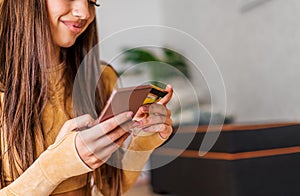 Smiling caucasian girl, checking bank balance, using phone