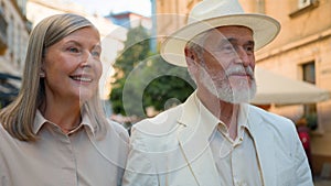 Smiling Caucasian happy family old couple elegant man gentleman woman lady pensioners tourists walk city street cafe