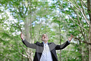 Smiling caucasian man in a forest - success relax freedom concept
