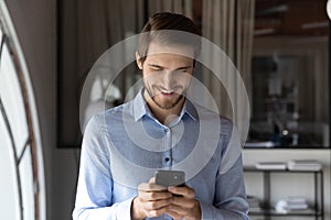 Smiling caucasian man using modern smartphone gadget