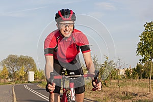 Smiling Caucasian Road Cyclist During Ride on Bike Outdoors