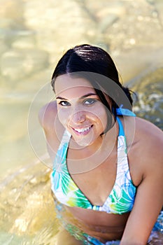Smiling Caucasian Woman In Blue Bikini Sitting In River