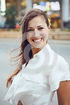 Smiling Caucasian woman girl with blue eyes with messy blond long hair on windy day outdoor, toned with Instagram filters