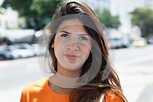 Smiling caucasian woman in a orange shirt in the city