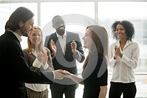 Smiling ceo handshaking successful female worker showing respect