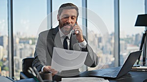 Smiling ceo having mobile phone conversation in office. Confident lawyer discuss