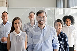 Smiling ceo looking at camera in office with diverse team