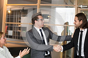 Smiling CEO congratulating male manager with job promotion photo