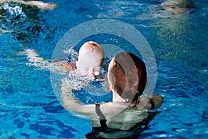 Smiling charming baby in swimming pool