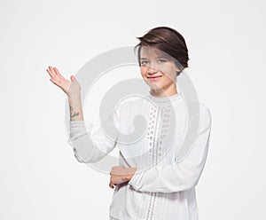 Smiling charming young female holding copyspace on palm