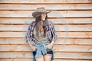 Smiling charming young woman cowgirl standing