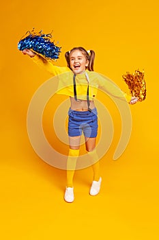 Smiling cheerleader girl with shiny pompons