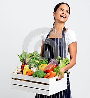 Smiling chef with apron holding fresh local organic produce
