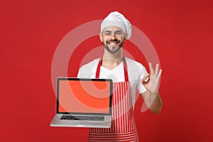 Smiling chef cook baker man in striped apron t-shirt toque chefs hat isolated on red background. Cooking food concept