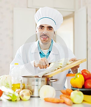 Smiling chef does veggy lunch