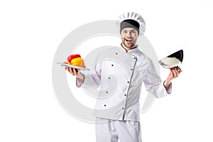 smiling chef with fresh bell peppers on serving tray