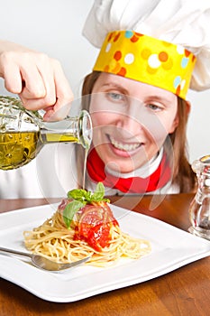 Smiling chef garnish an Italian pasta dish