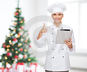 Smiling chef with tablet pc showing thumbs up