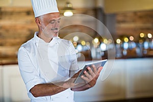 Smiling chef using digital tablet