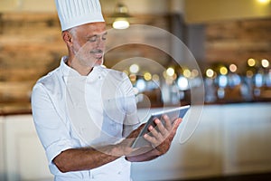 Smiling chef using digital tablet