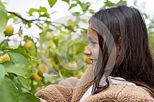 Smiling Child Amongst Lemon Branches.