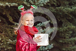 Smiling child with Christmas hoop holding gift box