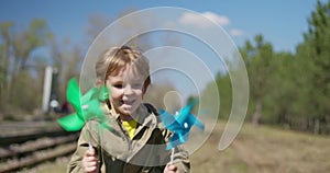 Smiling Child with Colorful Pinwheels Outdoors